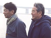 風に吹かれて青年二人。小田成光先生（左）と田原先生（右）。松花江上の船上にて。1995年10月。撮影は今は亡き島田隆英先生。